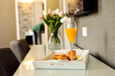 a glass of orange juice next to a box of food at Belgrade Inn Garni Hotel in Belgrade