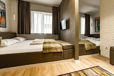a hotel room with two beds and a tv at Belgrade Inn Garni Hotel in Belgrade