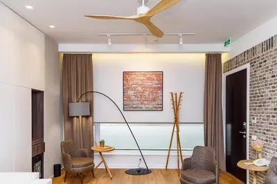 a living room with a ceiling fan and chairs at Belgrade Inn Garni Hotel in Belgrade