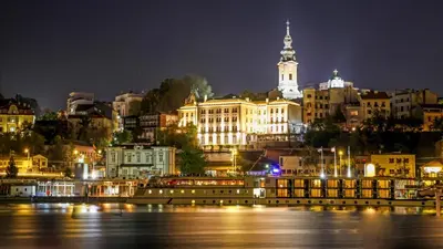 a city lit up at night with a river and buildings at Belgrade Inn Garni Hotel in Belgrade