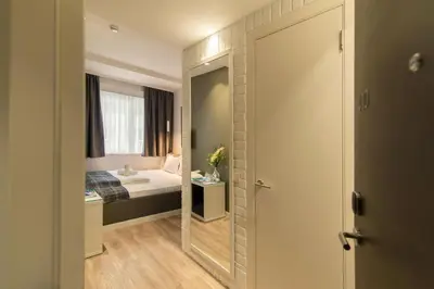 a small bedroom with a bed and a mirror at Belgrade Inn Garni Hotel in Belgrade