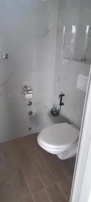 a bathroom with a toilet with a f on the wall at All SEASON in Beograd