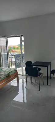 a room with a table and chairs and a balcony at All SEASON in Beograd