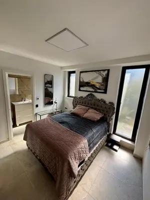 a bedroom with a bed in a room with windows at ONYX Grand SPA Suite Zemun in Belgrade