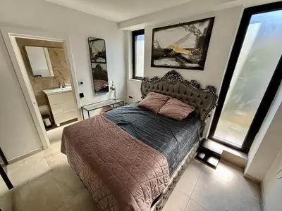 a bedroom with a bed and a bathroom with windows at ONYX Grand SPA Suite Zemun in Belgrade
