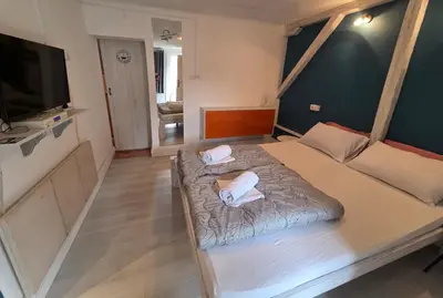 a bedroom with a large bed with two white towels at Appartamento con ingresso privato e vista giardino in Belgrade