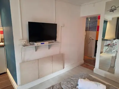 a living room with a flat screen tv on a wall at Appartamento con ingresso privato e vista giardino in Belgrade