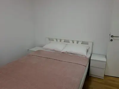 a bed with two pillows in a white room at Apartman ANDJA in Smederevo