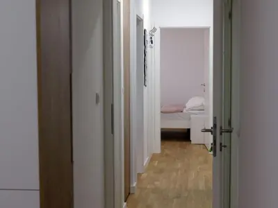a hallway with a bedroom and a bed in a room at Apartman ANDJA in Smederevo