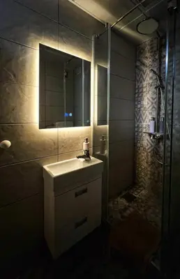 a bathroom with a sink and a shower with a mirror at Blok 63 in Beograd