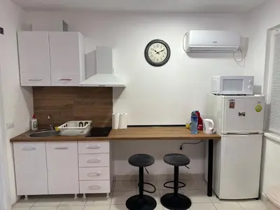 a kitchen with a counter and a refrigerator and a clock at Cozy studio in Belgrade in Belgrade