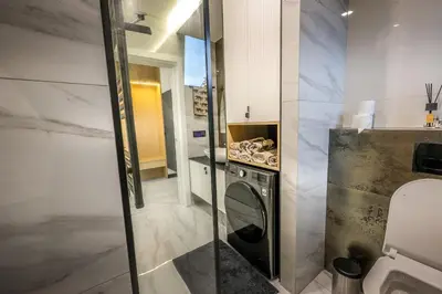 a small bathroom with a washer and dryer at Villa Cocosinella Belgrade in Surčin