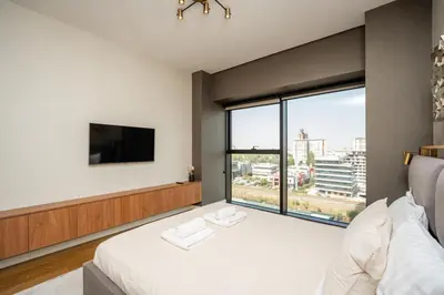 a bedroom with a bed and a large window at Star West Luxury in Belgrade