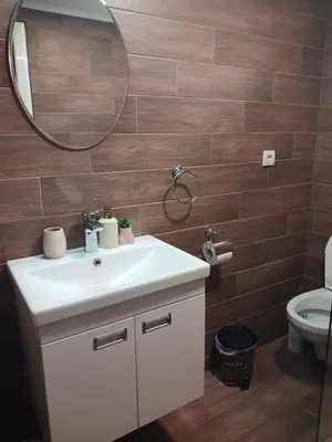 a bathroom with a sink and a mirror and a toilet at Apartman IN Pančevo in Pančevo