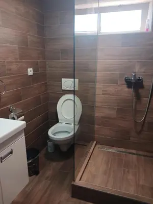 a bathroom with a toilet and a glass shower at Apartman IN Pančevo in Pančevo