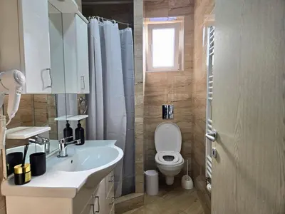 a bathroom with a sink and a toilet and a window at Airport 2BR Suite Filip in Beograd