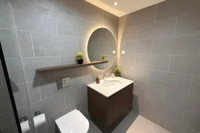 a bathroom with a sink and a toilet and a mirror at Belgrade Waterfront LuX Sky Residence in Belgrade