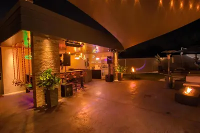 a large room with a table and chairs and lights at House California