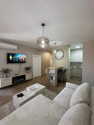 a living room with a white couch and a clock at The Wolf Residence in Inđija