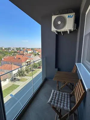 a room with a balcony with a fan and a bench at The Wolf Residence in Inđija