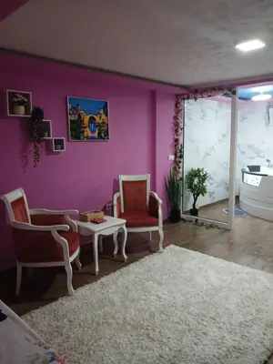 a living room with purple walls and two chairs and a table at Stan Na Dan Pancevo in Pančevo
