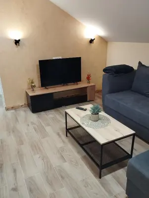 a living room with a couch and a flat screen tv at Belgrade City Home in Belgrade