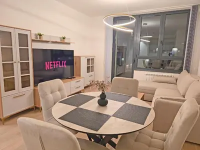 a living room with a table and a tv at Eterna Premium Apartment 1 Bedroom in Sajmište
