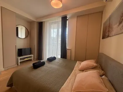 a bedroom with a large bed and a television at NEW! Modern Studio Belgrade Waterfront in Belgrade