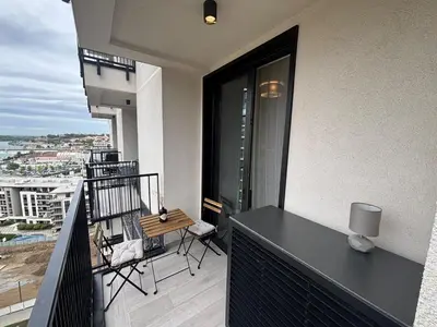 a balcony with a table and chairs on a building at NEW! Modern Studio Belgrade Waterfront in Belgrade