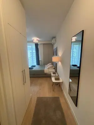 a small room with a bed and a mirror at NEW! Modern Studio Belgrade Waterfront in Belgrade