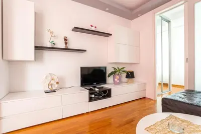 a living room with white cabinets and a tv at DC Belgrade, modern, super comfy, garage parking in Belgrade