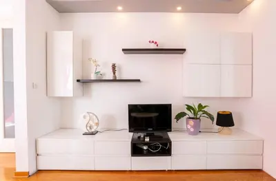 a living room with white cabinets and a tv at DC Belgrade, modern, super comfy, garage parking in Belgrade