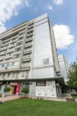 a tall white building with a sign on it at DC Belgrade, modern, super comfy, garage parking in Belgrade