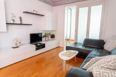 a living room with a couch and a tv at DC Belgrade, modern, super comfy, garage parking in Belgrade