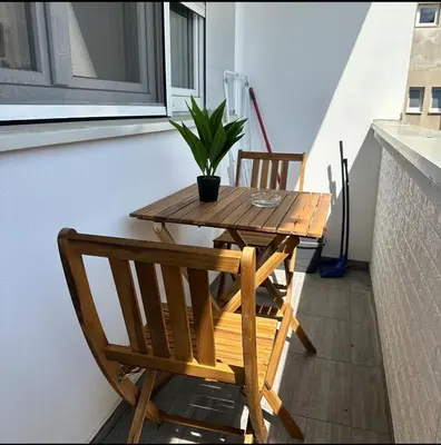 a wooden table with two chairs and a potted plant at Belgrade Central Residence in Belgrade