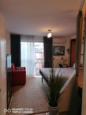 a bedroom with a bed and a living room at City pioneer Apartmens in Belgrade