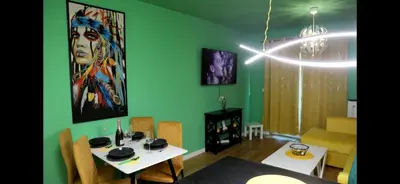 a living room with a table and a painting on the wall at 1 Bedroom Apartment Belgrade in Belgrade