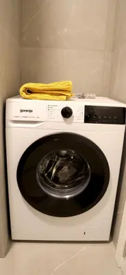 a white washing machine with a yellow towel on top at 1 Bedroom Apartment Belgrade in Belgrade