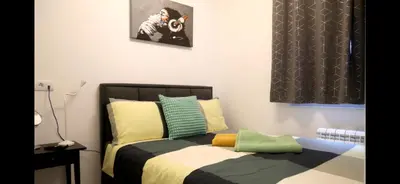 a bedroom with a bed with yellow and green pillows at 1 Bedroom Apartment Belgrade in Belgrade