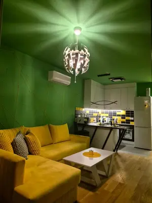 a green living room with a couch and a table at 1 Bedroom Apartment Belgrade in Belgrade