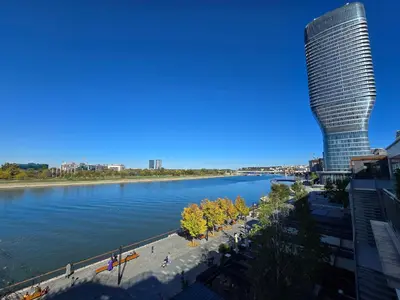 a view of a river with a tall building at BW Eterna deluxe apartments in Belgrade