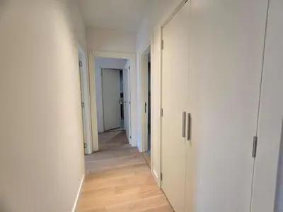 an empty hallway with white walls and wooden floors at BW Eterna deluxe apartments in Belgrade