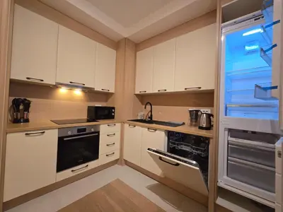 a kitchen with white cabinets and a black appliance at BW Eterna deluxe apartments in Belgrade