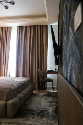 a hotel room with a bed and a flat screen tv at Luxurious 2BR Designer Apartment Near River & Park in Belgrade