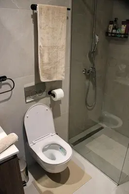 a bathroom with a white toilet and a shower at Luxurious 2BR Designer Apartment Near River & Park in Belgrade