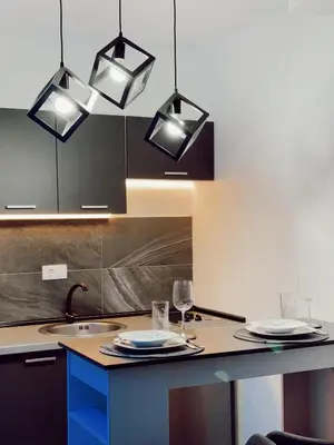 a kitchen with three lights hanging over a counter at Honey apartments in Ledine