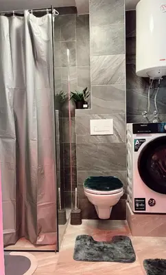 a bathroom with a toilet and a washing machine at Honey apartments in Ledine