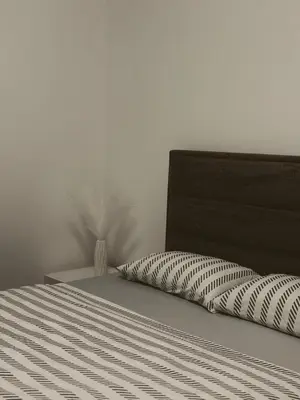 a bed with a black headboard and a pillow at Honey apartments in Ledine