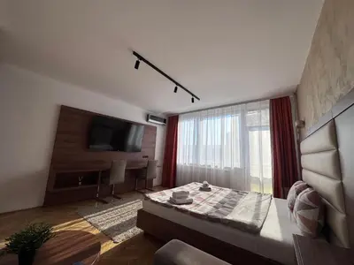 a living room with a bed and a large window at City View Apartments in Belgrade