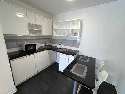 a kitchen with white cabinets and a black counter top at City View Apartments in Belgrade